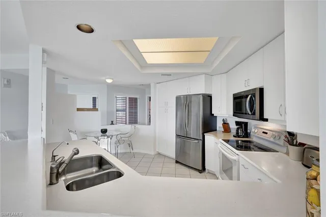 a kitchen with a refrigerator a microwave a sink and cabinets