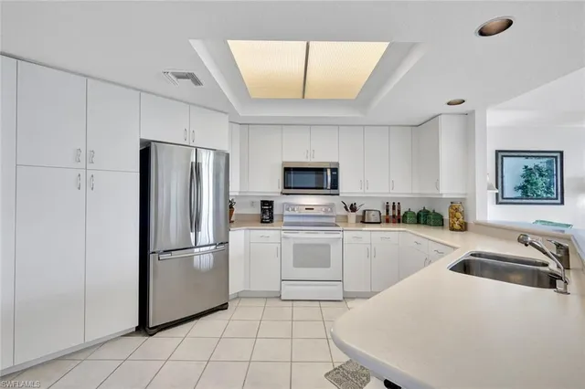 a kitchen with a sink appliances and cabinets
