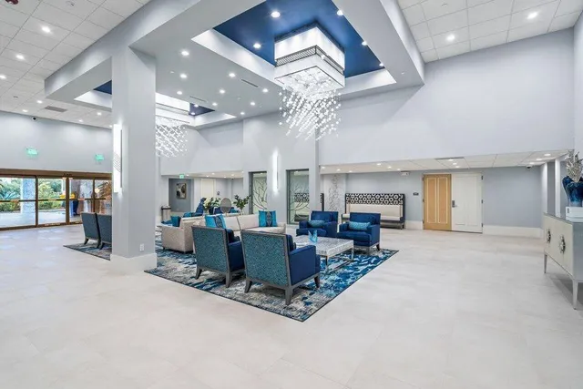 a living room with furniture a fireplace and a chandelier