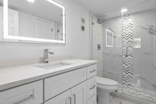 a bathroom with a sink a toilet and shower