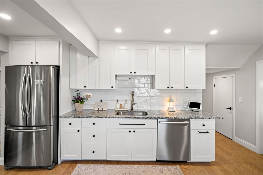 76 Perkins Street Stoneham, MA 02180 - Photo 14 of 40 a kitchen with stainless steel appliances granite countertop a refrigerator sink and white cabinets
