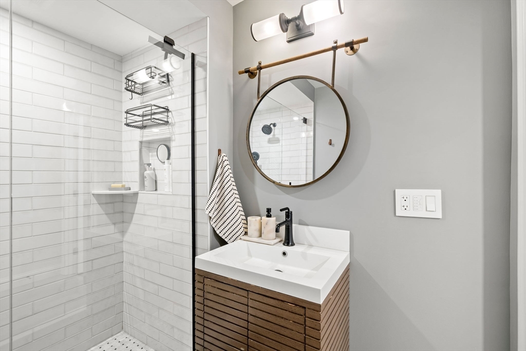 76 Perkins Street Stoneham, MA 02180 - Photo 23 of 40 a bathroom with a sink a mirror and a shower