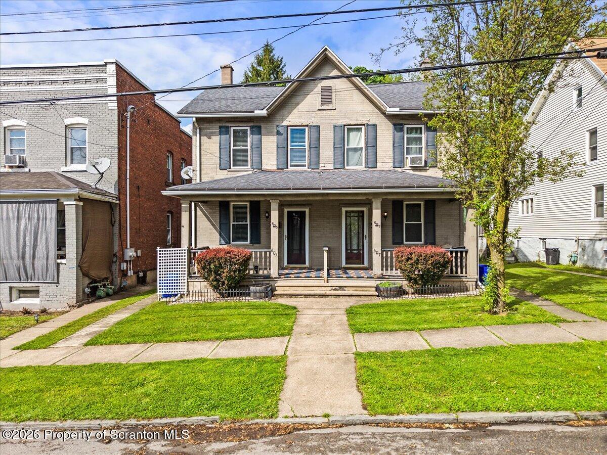 607 Deacon Street Scranton, PA 18509 - Photo 1 of 40 a view of a brick house with a yard lawn chairs and a large tree