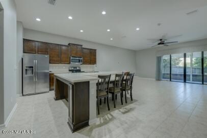 86192 Fortune Drive Yulee, FL 32097 - Photo 17 of 33 a kitchen with stainless steel appliances kitchen island granite countertop a stove a sink a refrigerator and a dining table with wooden floor