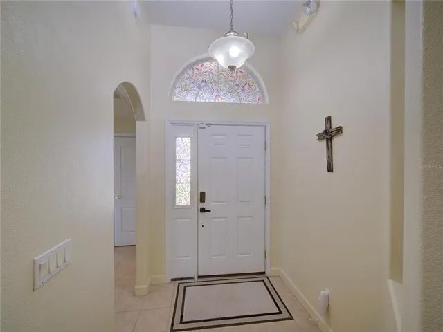 a view of a hallway with windows and chandelier