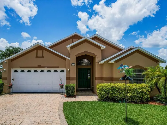 a front view of a house with a garden and plants