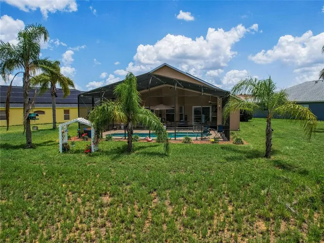 a view of a house with backyard and sitting area