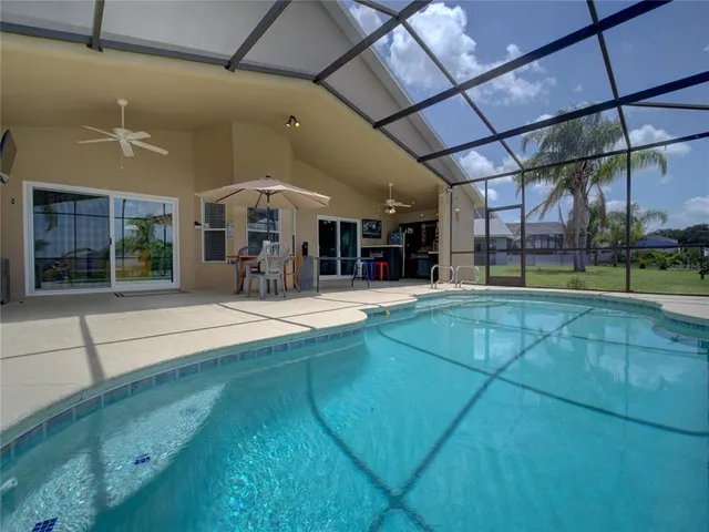 a view of a backyard with table and chairs under an umbrella