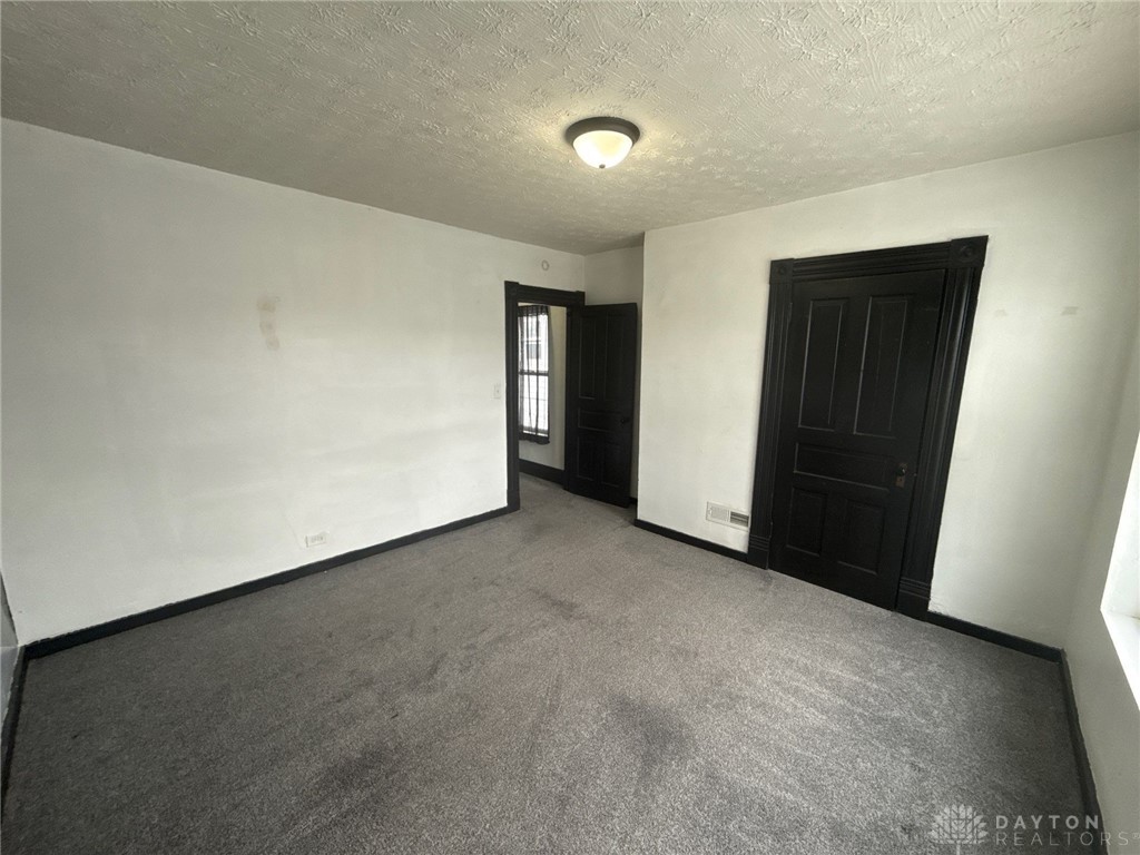1125 West High Street Springfield, OH 45506 - Photo 21 of 39 This versatile room features plush carpeting and classic dark trim, offering a blank canvas for personalization.