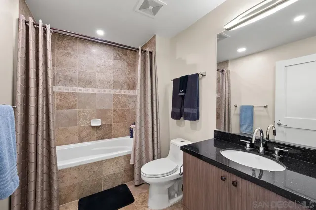 a bathroom with a granite countertop sink toilet and shower