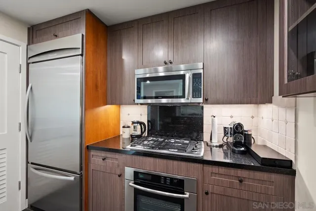 a kitchen with a refrigerator and a stove top oven