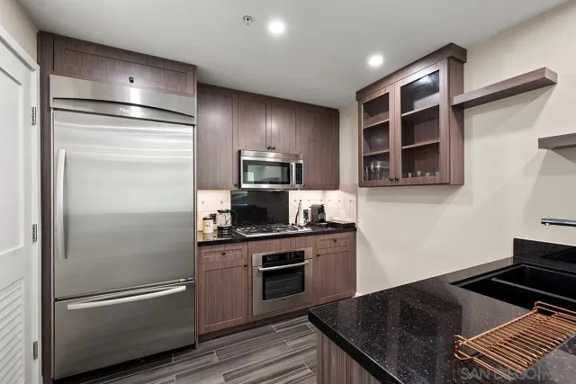 a kitchen with a refrigerator and a stove top oven