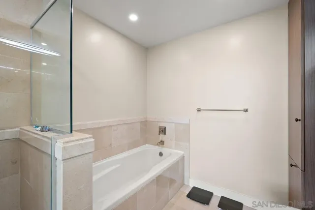 a bathroom with a tub a sink and a mirror