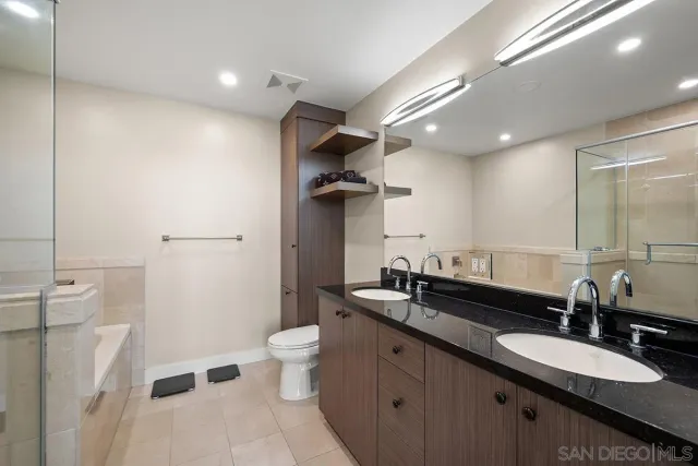a bathroom with a double vanity sink toilet and a mirror