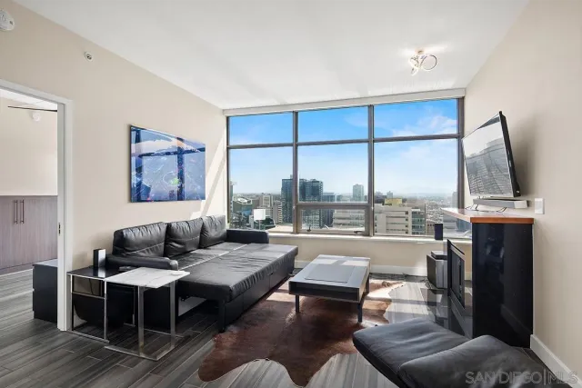 a living room with furniture a large window and a flat screen tv