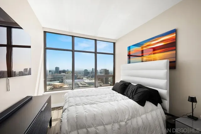 a bedroom with a bed and a large window