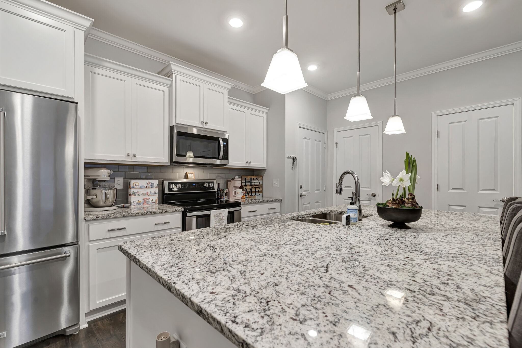 a kitchen with stainless steel appliances granite countertop a sink a refrigerator and a granite counter tops