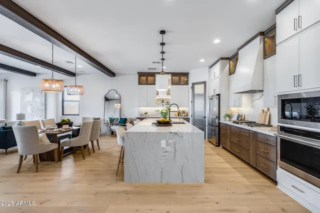 a kitchen with stainless steel appliances granite countertop a stove oven and a dining table with wooden floor