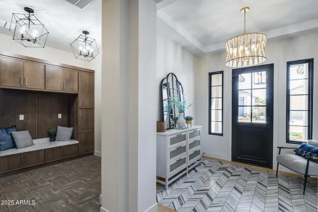 a kitchen with stainless steel appliances granite countertop a stove a sink a microwave a refrigerator and white cabinets with wooden floor