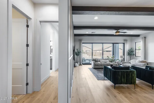 a living room with sink mirror and a wooden floor