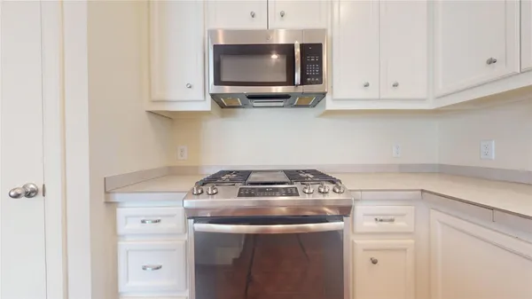 a kitchen with a stove and a white cabinet