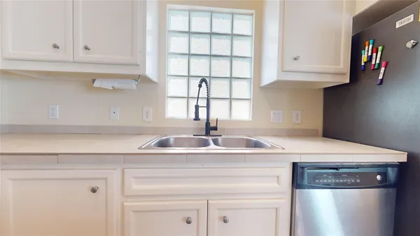 a kitchen with stainless steel appliances granite countertop a sink a stove and white cabinets