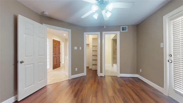 a view of an empty room with window and wooden floor