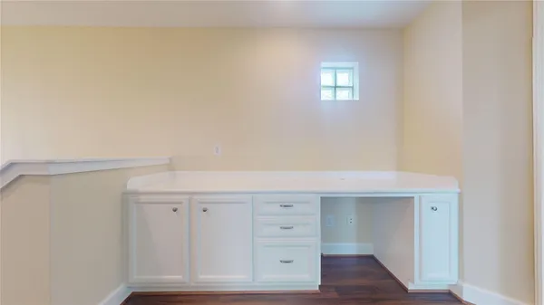 an empty room with wooden floor chandelier fan and windows