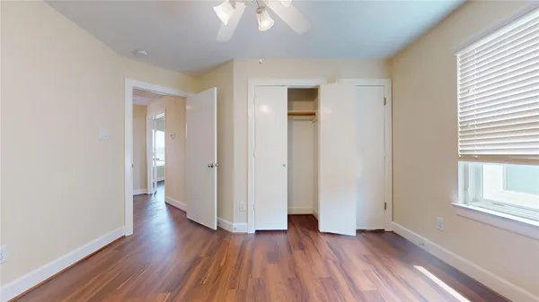 a view of a room with wooden floor and a ceiling fan