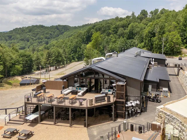a view of a roof deck with table and chairs couches with wooden floor