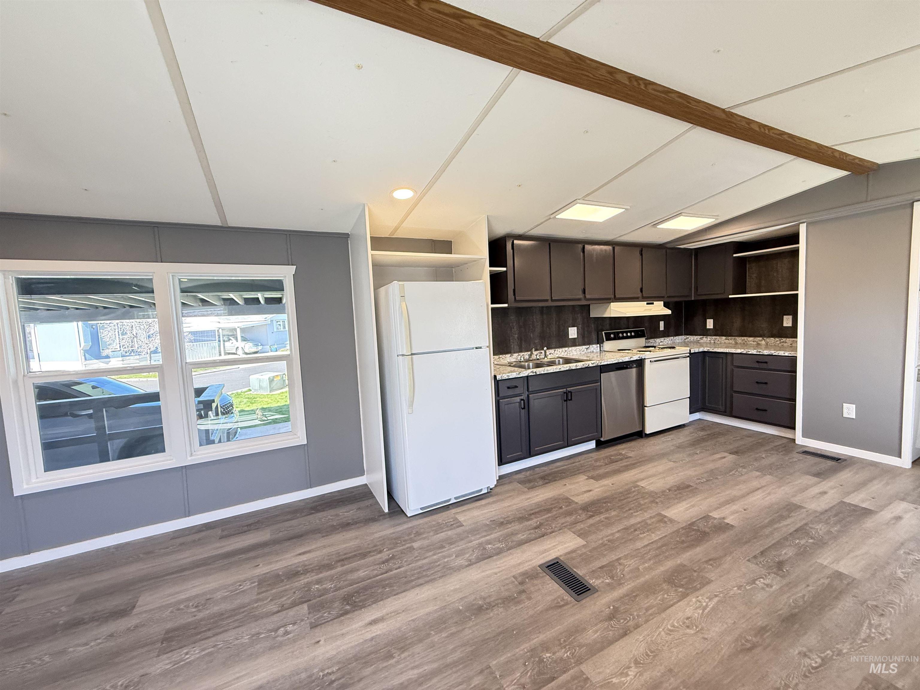 2015 6th Avenue, Unit 321 Clarkston, WA 99403 - Photo 11 of 34 Kitchen with open shelves, white appliances, light countertops, dark wood-style floors, and vaulted ceiling