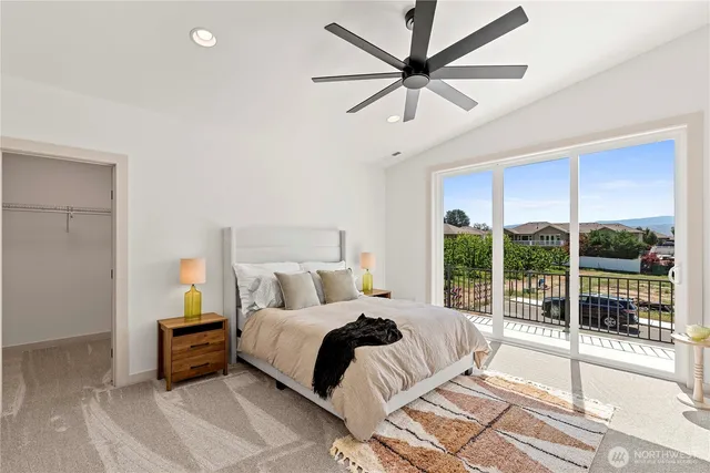 a bedroom with a large bed and a chandelier fan