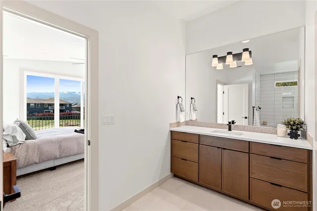 a en suite bathroom with a double vanity sink and a mirror