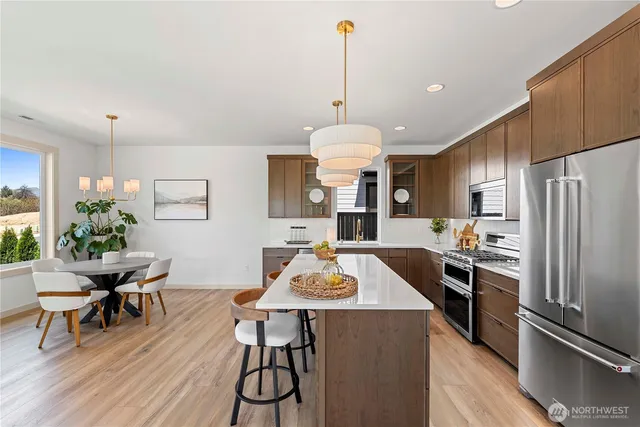 a kitchen with granite countertop stainless steel appliances a dining table and chairs