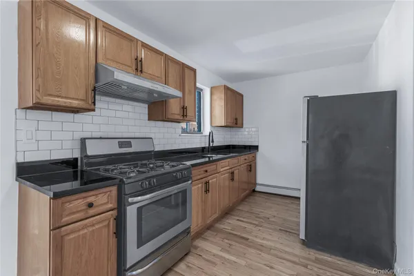 a kitchen with stainless steel appliances granite countertop a stove a sink and a refrigerator