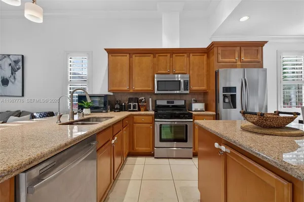 a kitchen with kitchen island granite countertop a sink and white cabinets with wooden floor