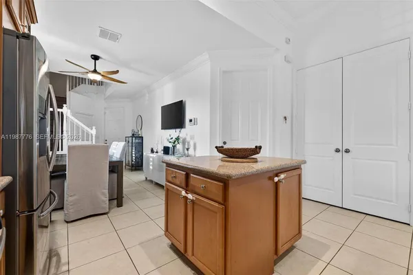 a kitchen with stainless steel appliances granite countertop a stove top oven a sink dishwasher a dining table and chairs with wooden floor