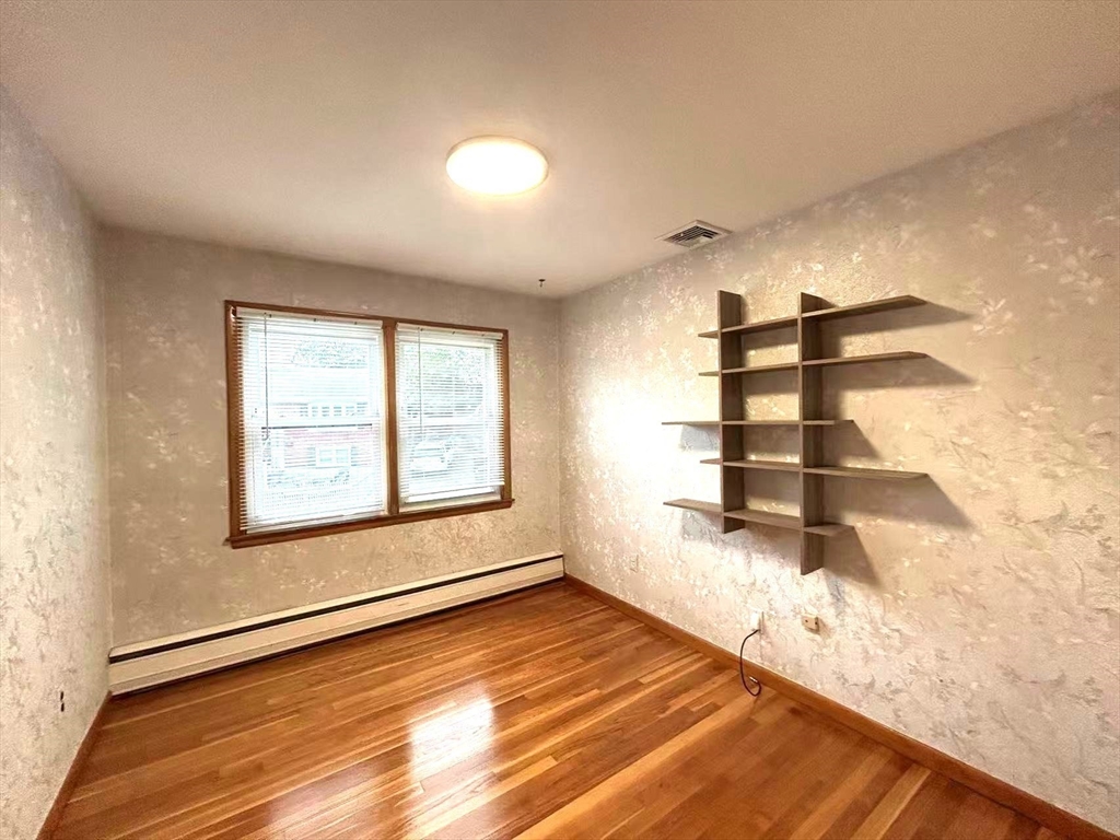 122 Running Brook Road Boston, MA 02132 - Photo 13 of 21 a view of empty room with wooden floor and windows