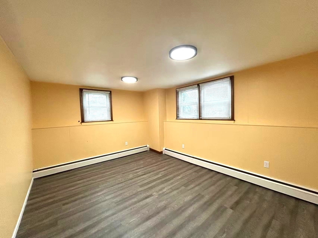 122 Running Brook Road Boston, MA 02132 - Photo 15 of 21 an empty room with wooden floor and windows