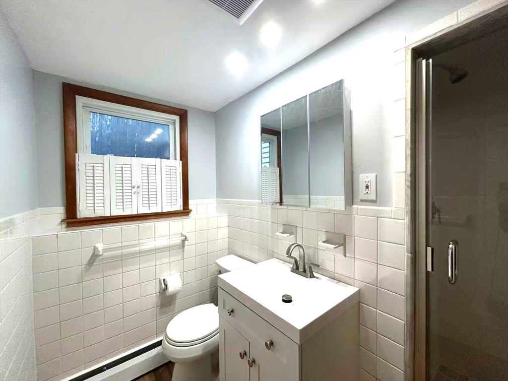 122 Running Brook Road Boston, MA 02132 - Photo 17 of 21 a bathroom with a toilet a sink and mirror