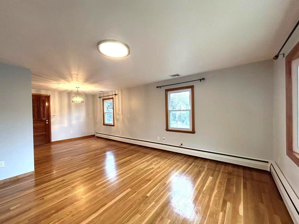122 Running Brook Road Boston, MA 02132 - Photo 7 of 21 an empty room with wooden floor and windows
