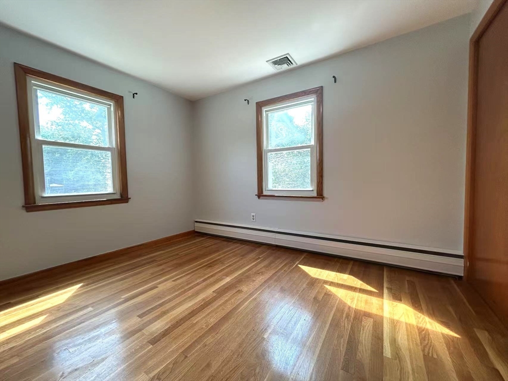 122 Running Brook Road Boston, MA 02132 - Photo 10 of 21 a view of an empty room with wooden floor and a window