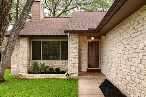 a front view of a house with a garden and yard