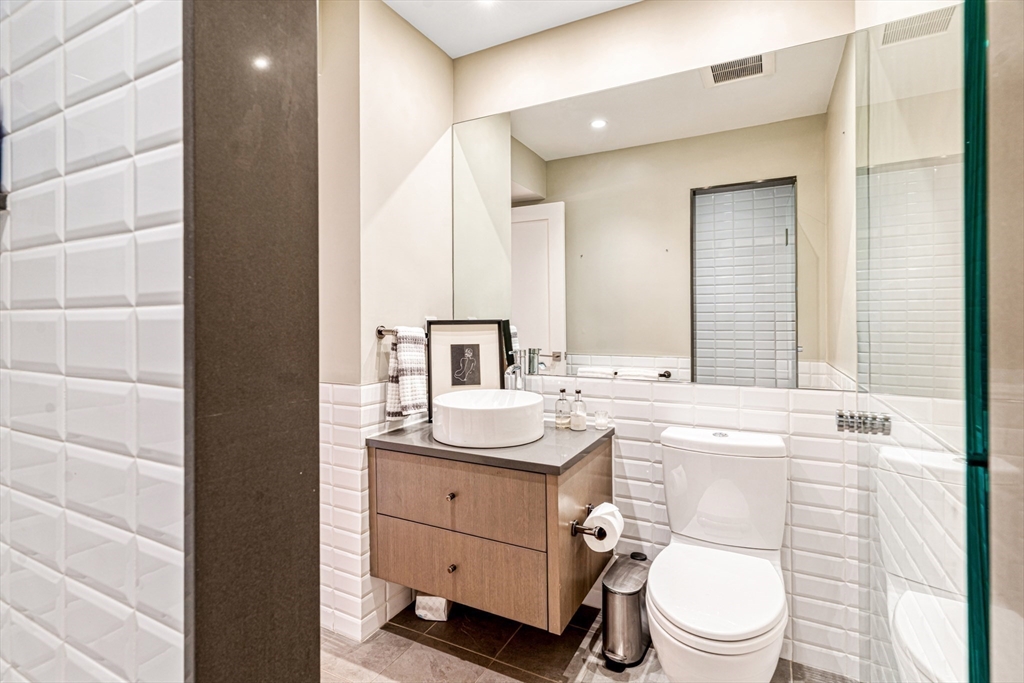 491 Massachusetts Avenue, Unit 1 Boston, MA 02118 - Photo 12 of 26 a bathroom with a sink a toilet and mirror
