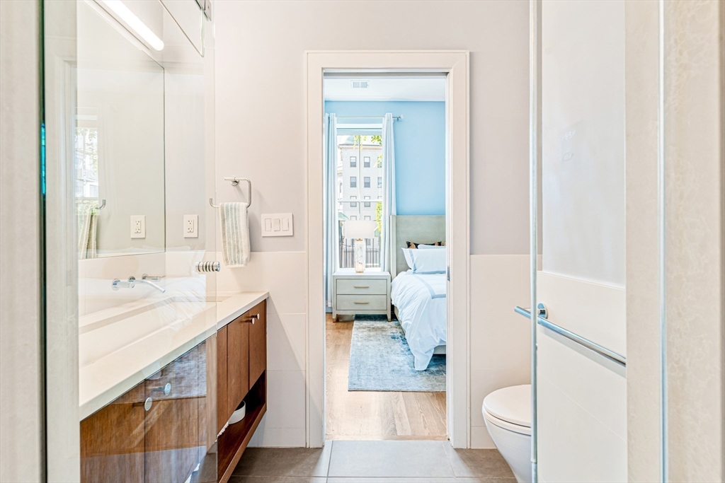 491 Massachusetts Avenue, Unit 1 Boston, MA 02118 - Photo 15 of 26 a bathroom with a granite countertop sink mirror vanity and toilet