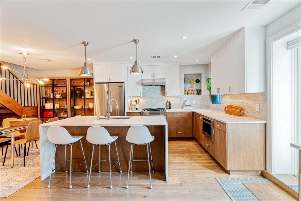 491 Massachusetts Avenue, Unit 1 Boston, MA 02118 - Photo 9 of 26 a kitchen with a dining table chairs and white cabinets
