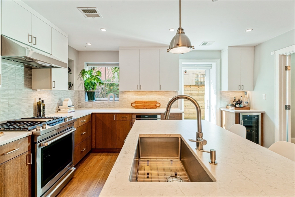491 Massachusetts Avenue, Unit 1 Boston, MA 02118 - Photo 10 of 26 a kitchen with stainless steel appliances granite countertop a stove a sink dishwasher and a stove with wooden floor