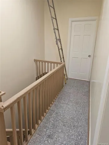 a view of staircase with railing and white walls