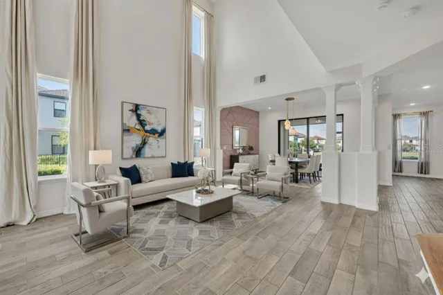 a large kitchen with white cabinets stainless steel appliances a dining table and a chandelier