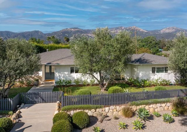 a front view of a house with a yard and a garden